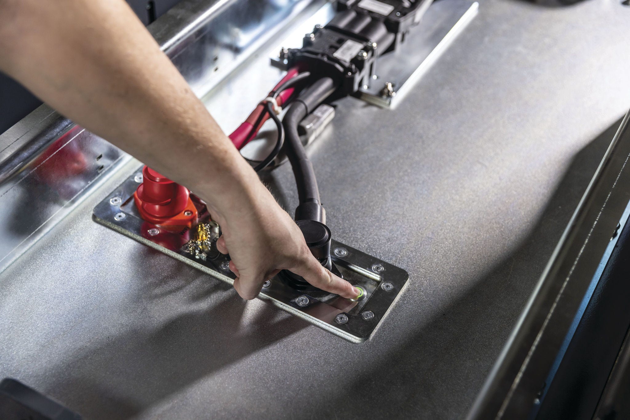 person's hand pressing power button on lithium-ion charger
